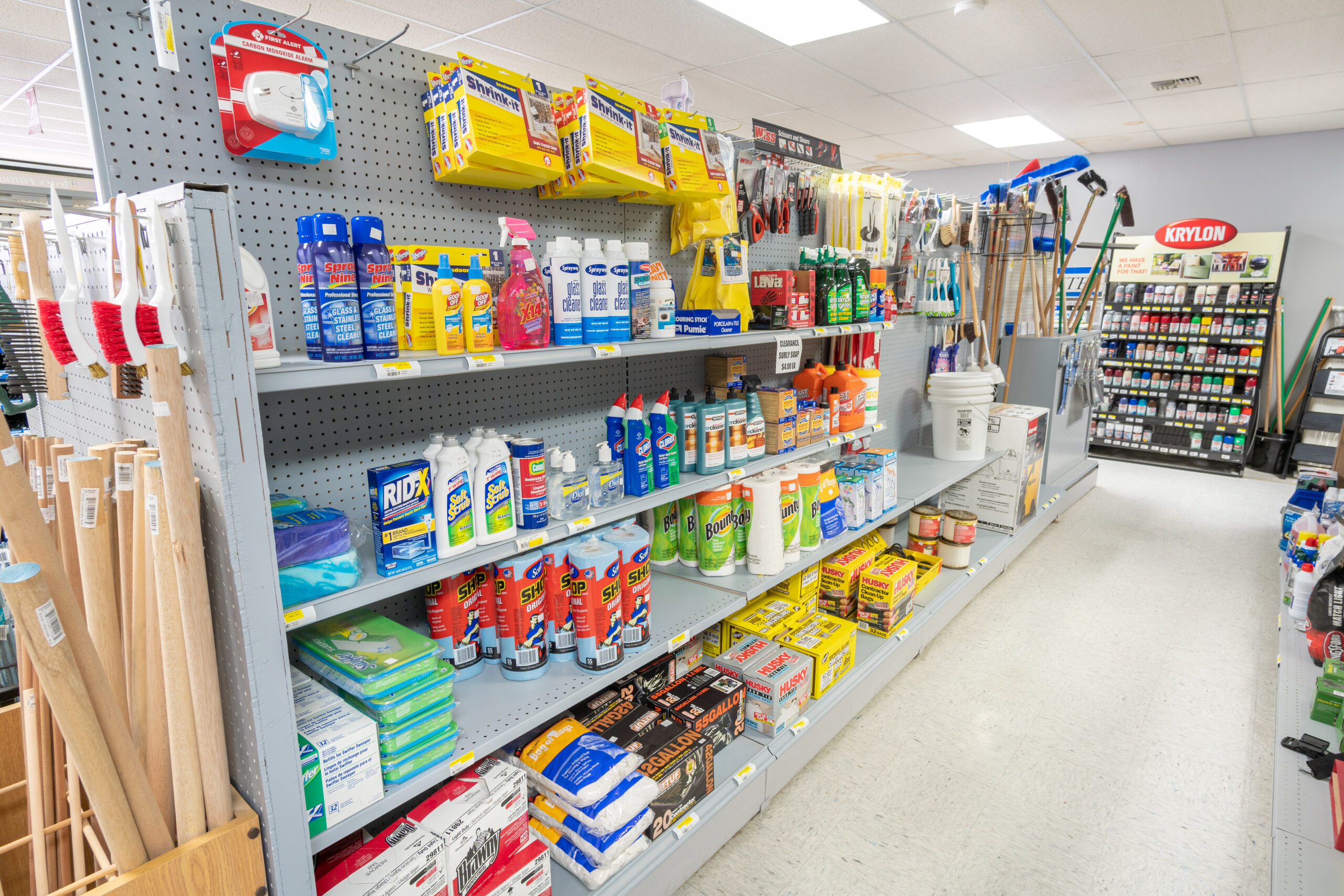 A shelf in Four Star Supply, full of cleaning supplies like bathroom cleaner, shop vacs, cleaning rags, and other products.