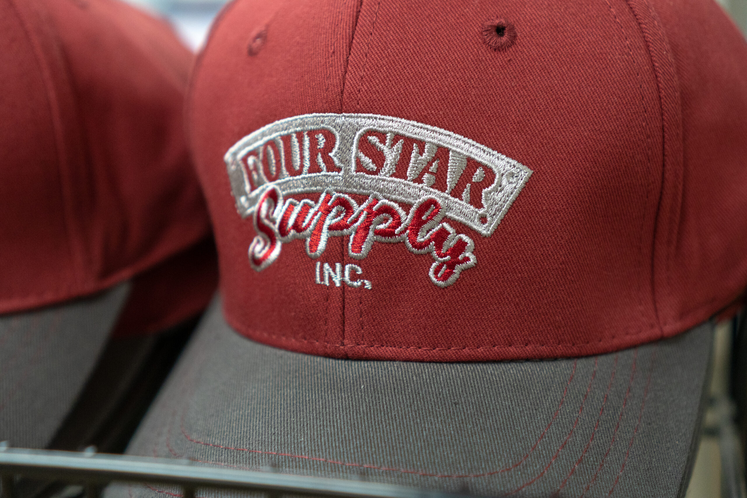 A closeup of a Four Star Supply branded Baseball hat