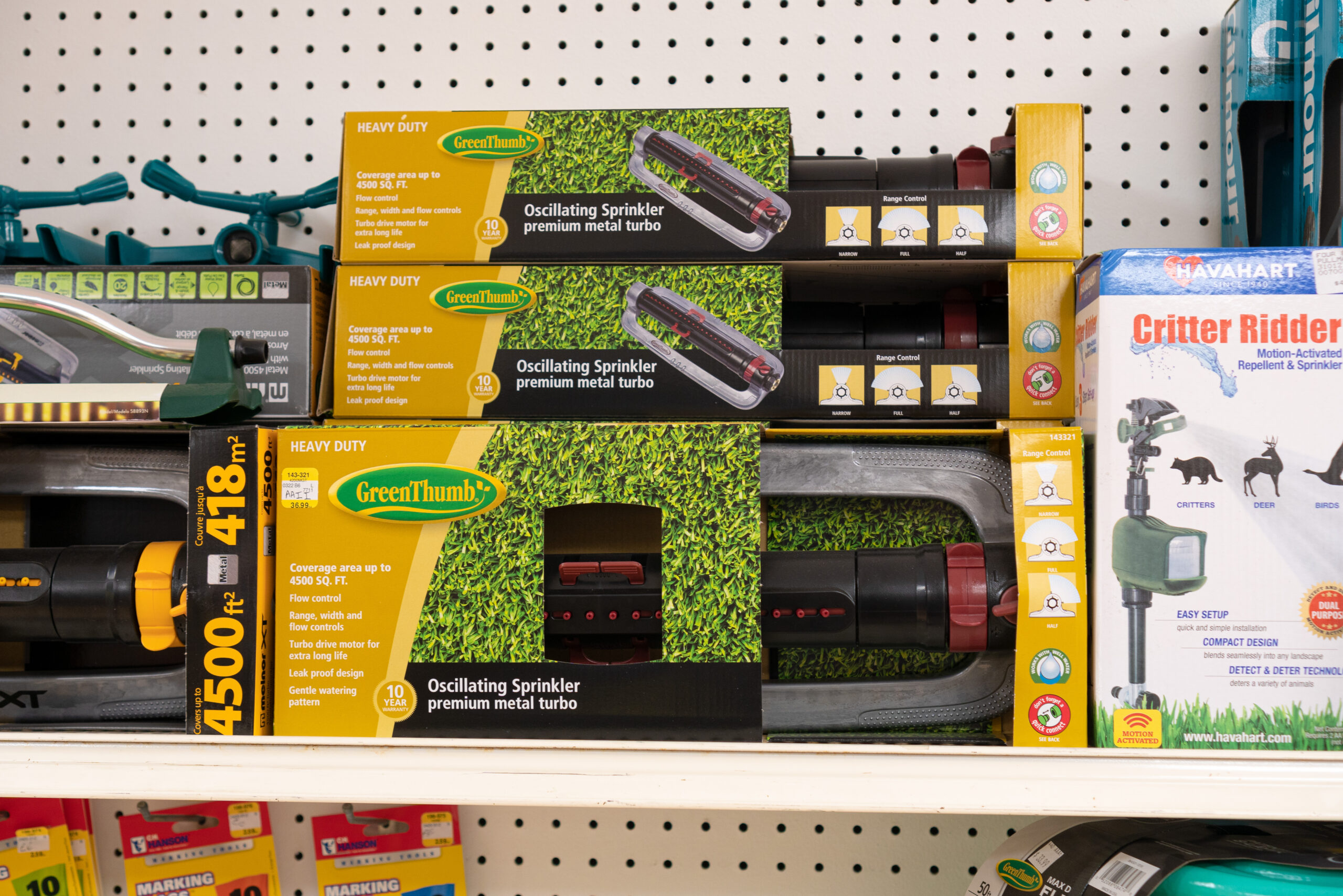 A shelf containing several boxes with Green Thumb brand Oscillating Sprinklers