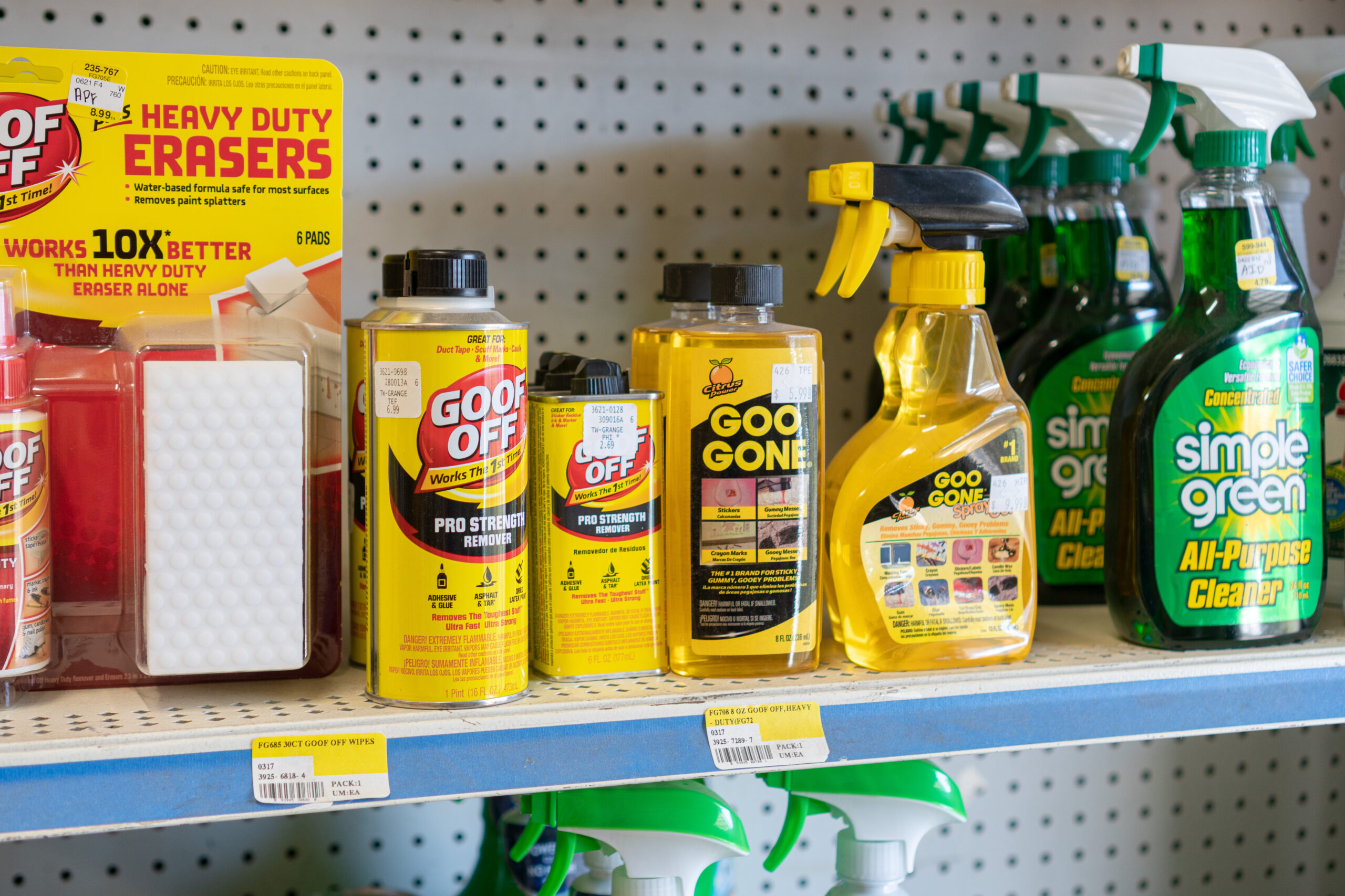 A shelf at Four Star Supply displaying Goof Off sponges, various Goo Gone products, and Simple Green all-purpose cleaner.