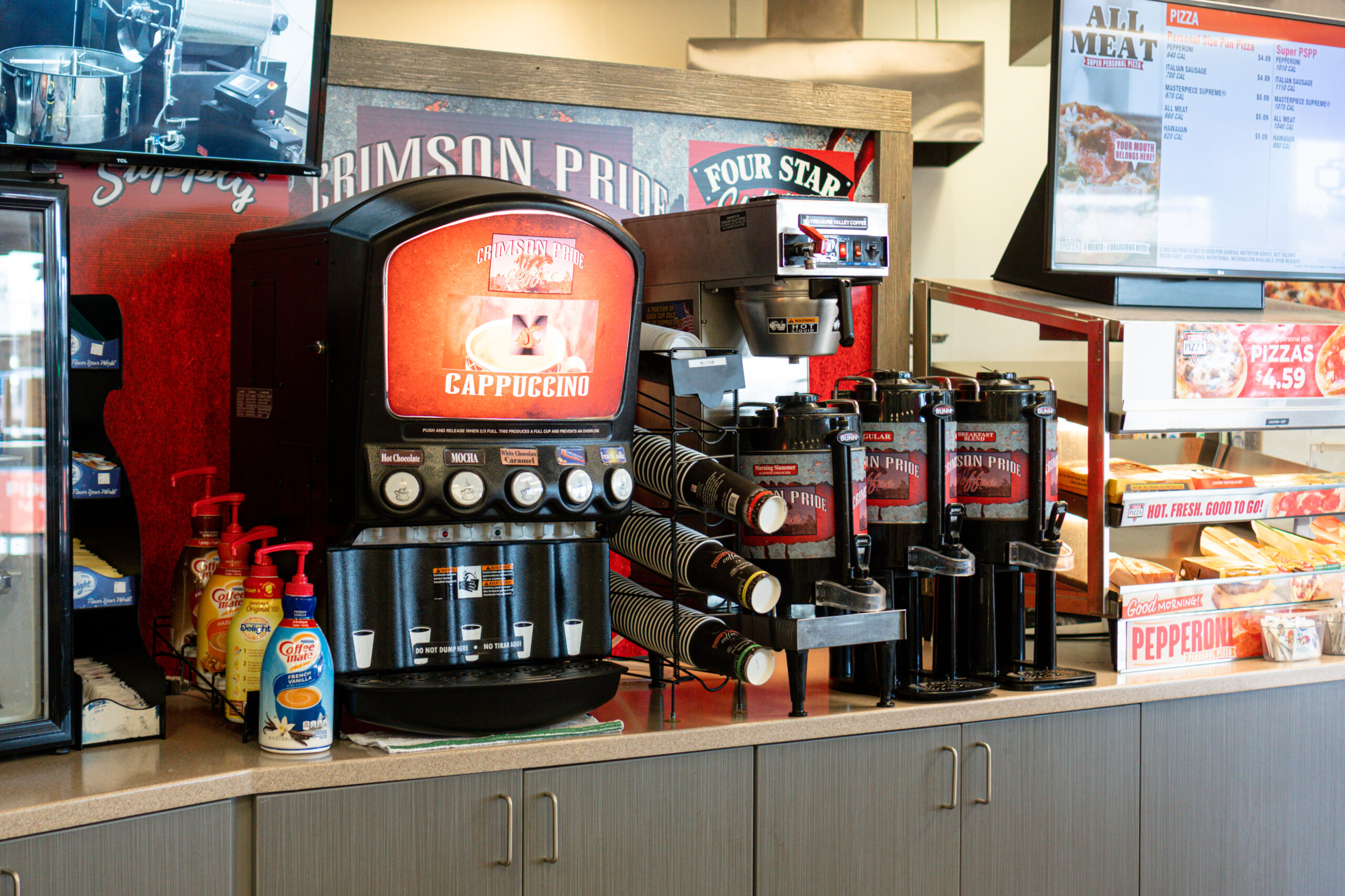 A coffee station next to a pizza station at a Four Star Supply owned convenience store
