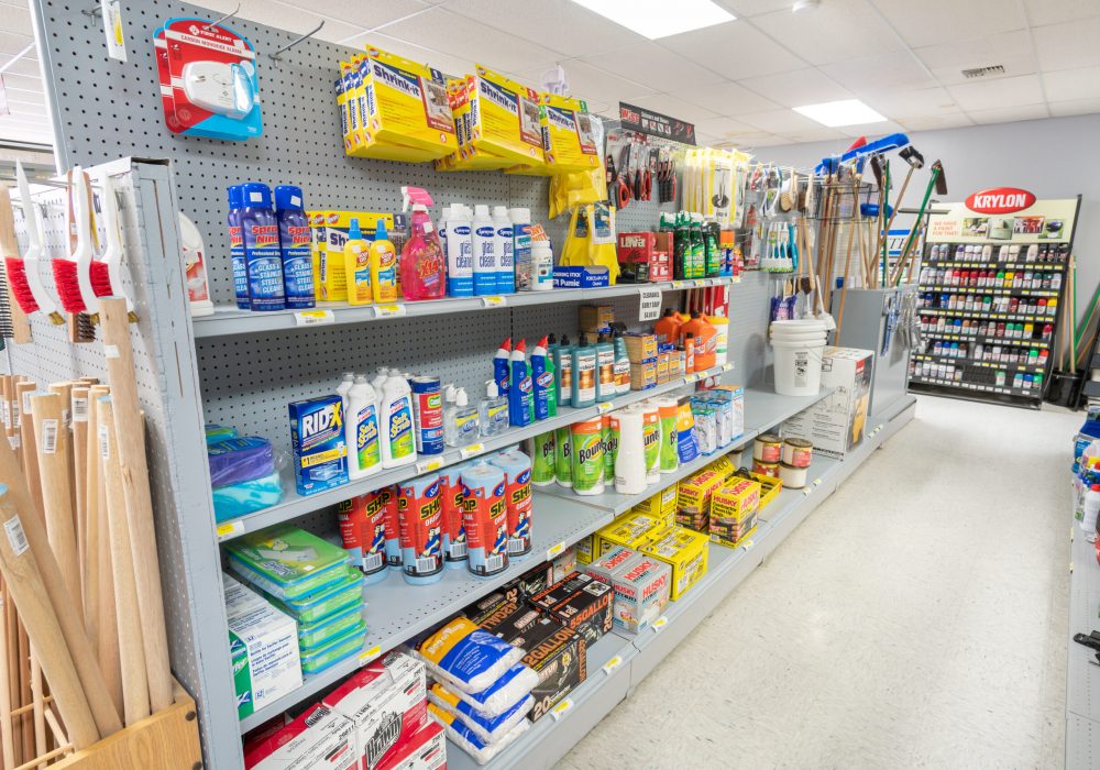 A shelf in Four Star Supply, full of cleaning supplies like bathroom cleaner, shop vacs, cleaning rags, and other products.