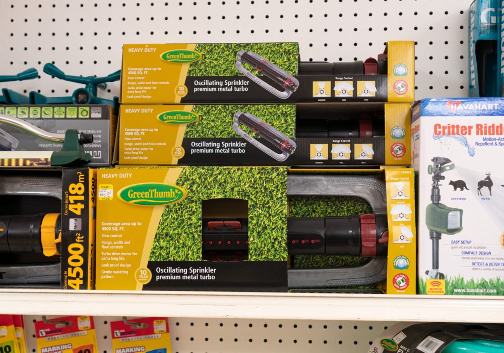 A shelf containing several boxes with Green Thumb brand Oscillating Sprinklers