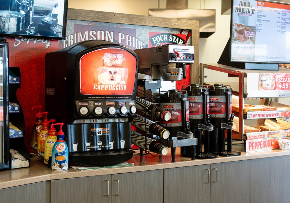 A coffee station next to a pizza station at a Four Star Supply owned convenience store